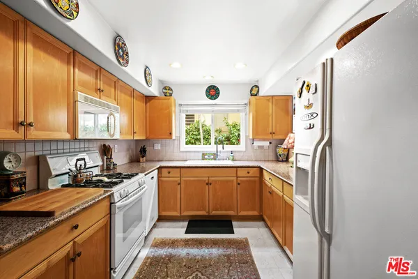 a kitchen with stainless steel appliances granite countertop a sink and a stove
