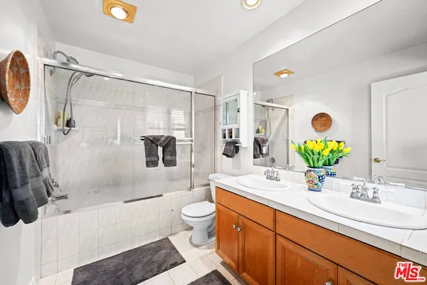 a bathroom with a double vanity sink toilet and shower