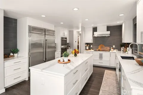 a large white kitchen with a white stove top oven and white cabinets