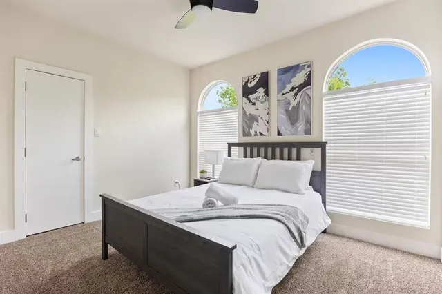 a bedroom with a bed and painting on the wall
