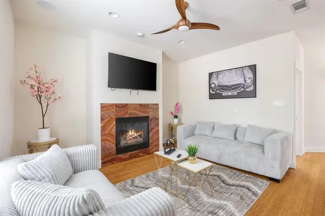 a living room with furniture a flat screen tv and a fireplace