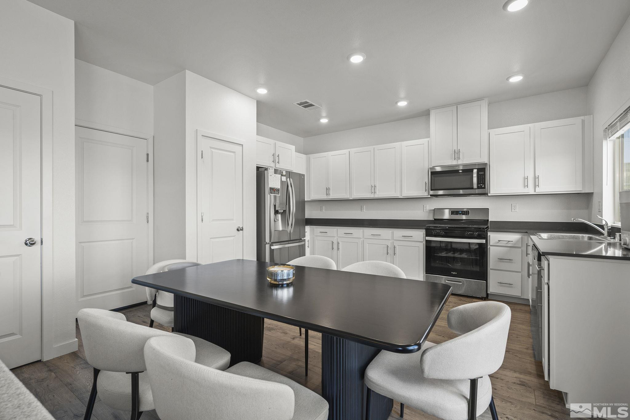 583 Iris Rainbow Drive Reno, NV 89506 - Photo 7 of 22 a kitchen with stainless steel appliances kitchen island granite countertop a dining table chairs and a refrigerator
