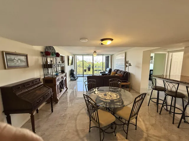 a living room with furniture a refrigerator and a flat screen tv