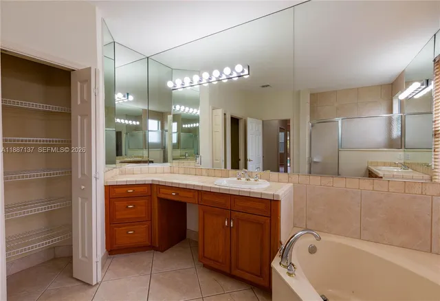 a bathroom with a granite countertop sink mirror and bathtub