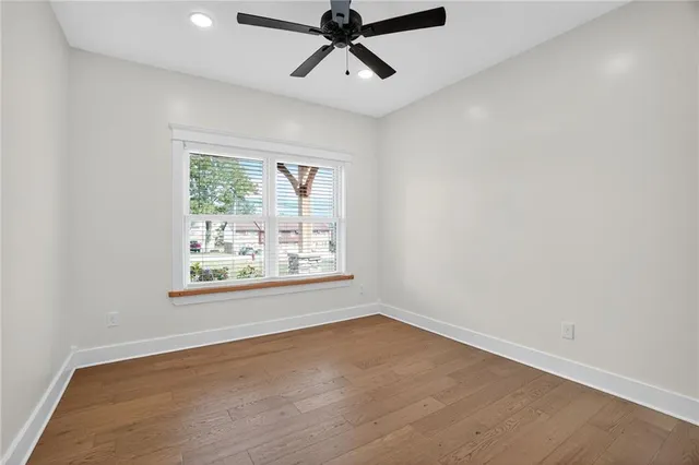 an empty room with a window and a ceiling fan
