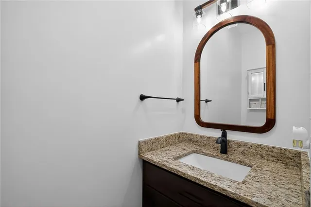 a bathroom with a granite countertop sink and a mirror
