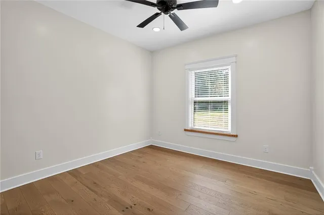 an empty room with a window and ceiling fan