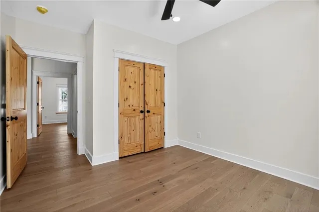 a view of a hallway with wooden floor and closet