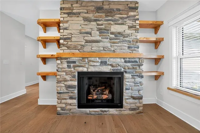a fireplace with a clock on wooden floor