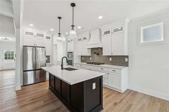 a kitchen with stainless steel appliances a kitchen island a stove a refrigerator and a sink