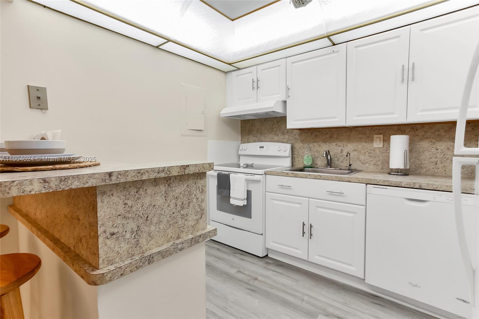 7300 Northwest 17th Street, Unit 220 Plantation, FL 33313 - Photo 13 of 27 a kitchen with white cabinets and white appliances