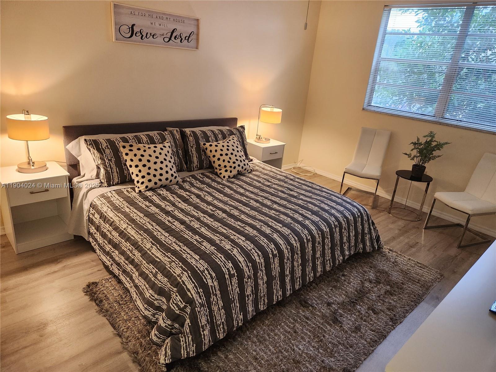 7300 Northwest 17th Street, Unit 220 Plantation, FL 33313 - Photo 17 of 27 a bedroom with a bed and wooden floor