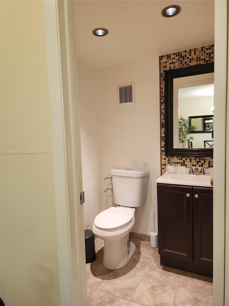 7300 Northwest 17th Street, Unit 220 Plantation, FL 33313 - Photo 21 of 27 a bathroom with a toilet sink and mirror
