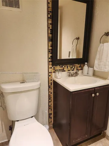a bathroom with a sink vanity mirror and toilet