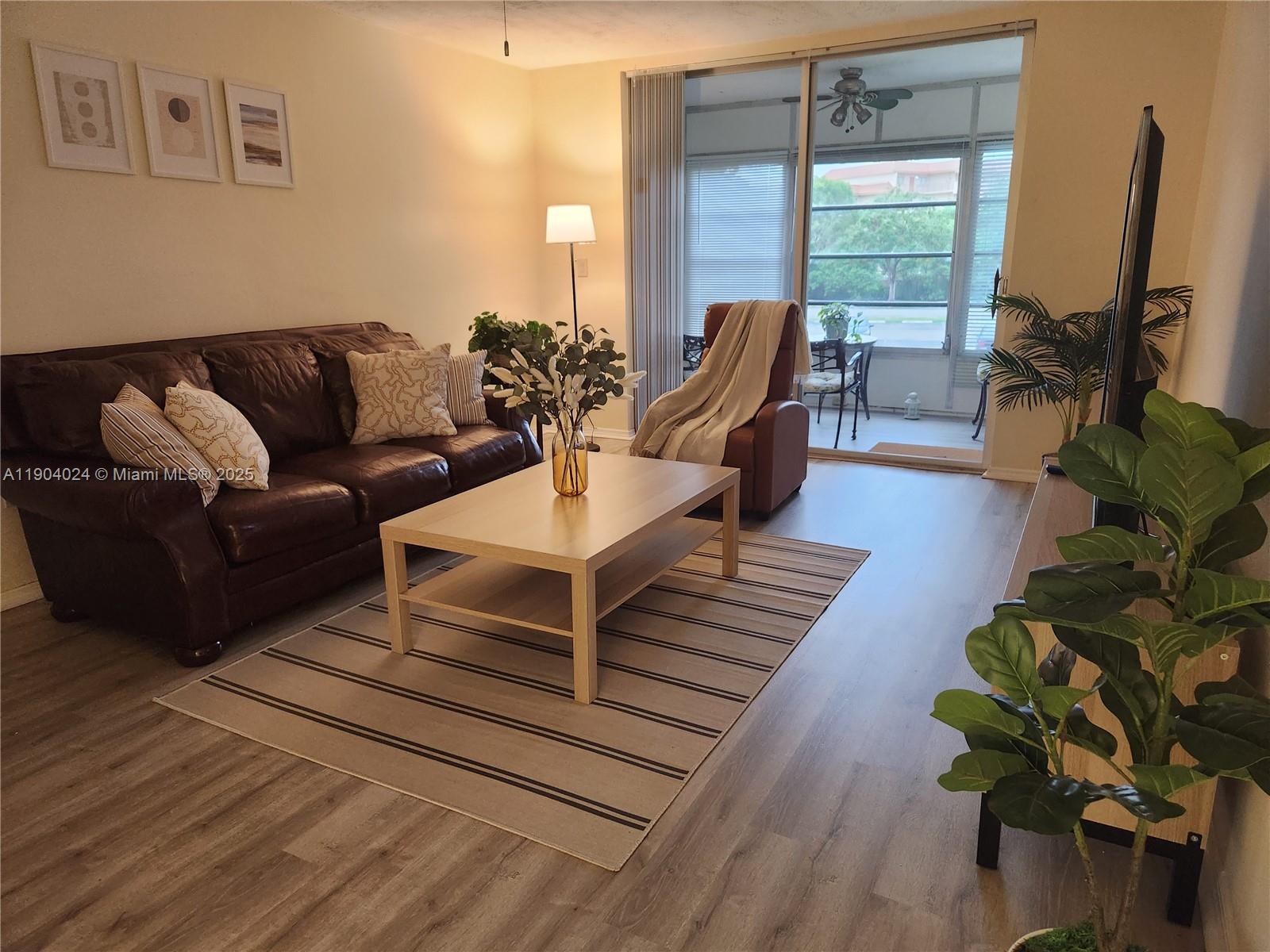 7300 Northwest 17th Street, Unit 220 Plantation, FL 33313 - Photo 3 of 27 a living room with furniture flat screen tv and a large window