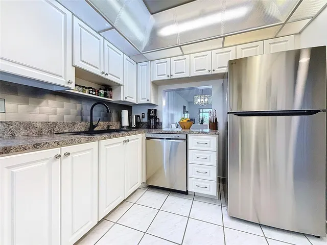 a kitchen with stainless steel appliances a refrigerator sink and cabinets