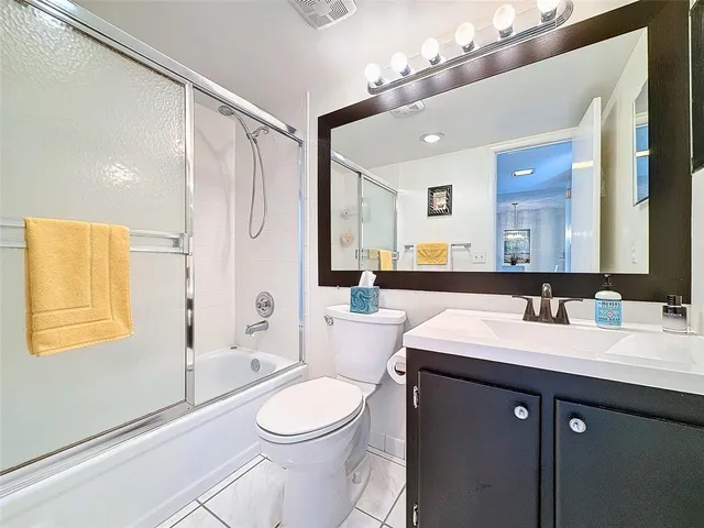 a bathroom with a sink a toilet a mirror a vanity and shower