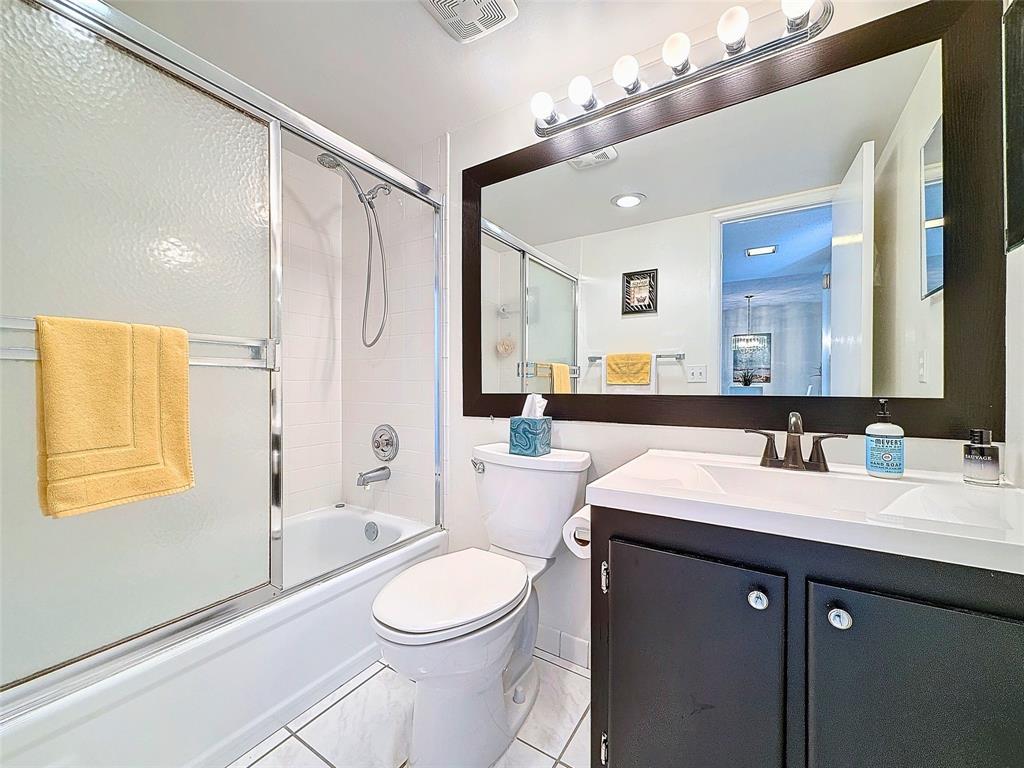 2309 South Cypress Bend Drive, Unit 515 Pompano Beach, FL 33069 - Photo 11 of 14 a bathroom with a sink a toilet a mirror a vanity and shower