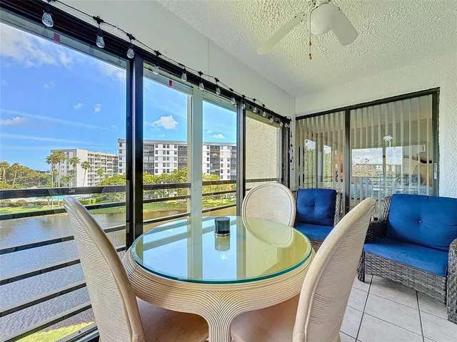 a view of a dining room with furniture a chandelier and large windows