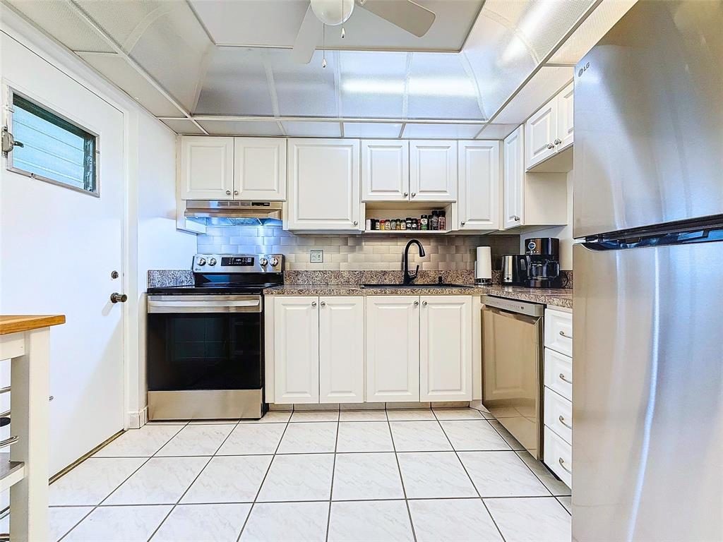 2309 South Cypress Bend Drive, Unit 515 Pompano Beach, FL 33069 - Photo 2 of 14 a kitchen with a sink a stove top oven and cabinets