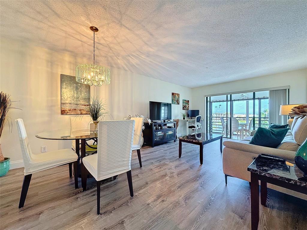 2309 South Cypress Bend Drive, Unit 515 Pompano Beach, FL 33069 - Photo 3 of 14 a living room with furniture and a wooden floor