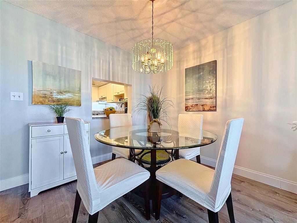 2309 South Cypress Bend Drive, Unit 515 Pompano Beach, FL 33069 - Photo 4 of 14 a view of a dining room with furniture and chandelier