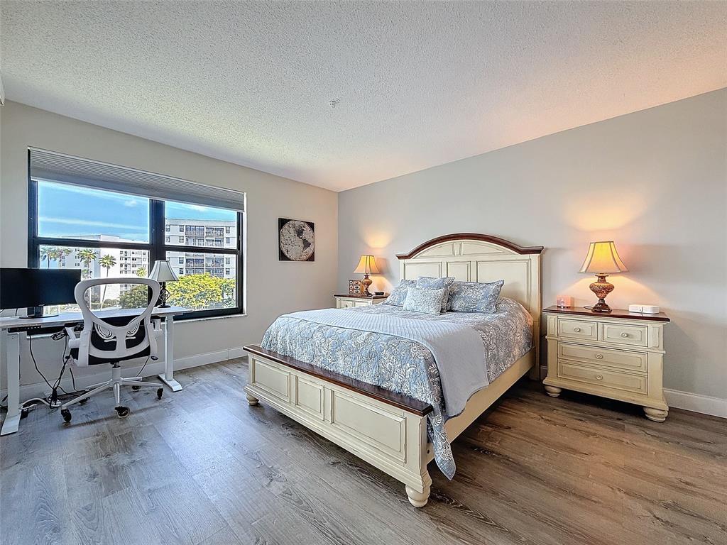 2309 South Cypress Bend Drive, Unit 515 Pompano Beach, FL 33069 - Photo 6 of 14 a bedroom with a bed and a desk