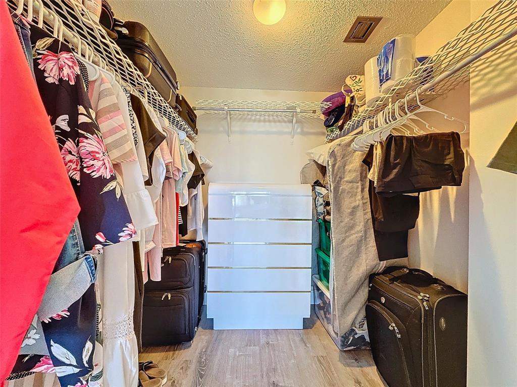 2309 South Cypress Bend Drive, Unit 515 Pompano Beach, FL 33069 - Photo 8 of 14 a view of walk in closet with clothes and shoes