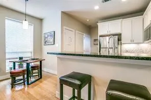 a kitchen with granite countertop white cabinets and chairs