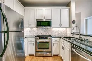 a kitchen with granite countertop a sink stove and microwave