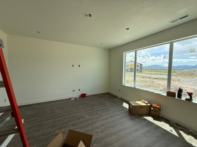 1008 West 3410 South Nibley, UT 84321 - Photo 6 of 26 Expansive room featuring wood-finish flooring, a large multi-pane window, and recessed ceiling lighting