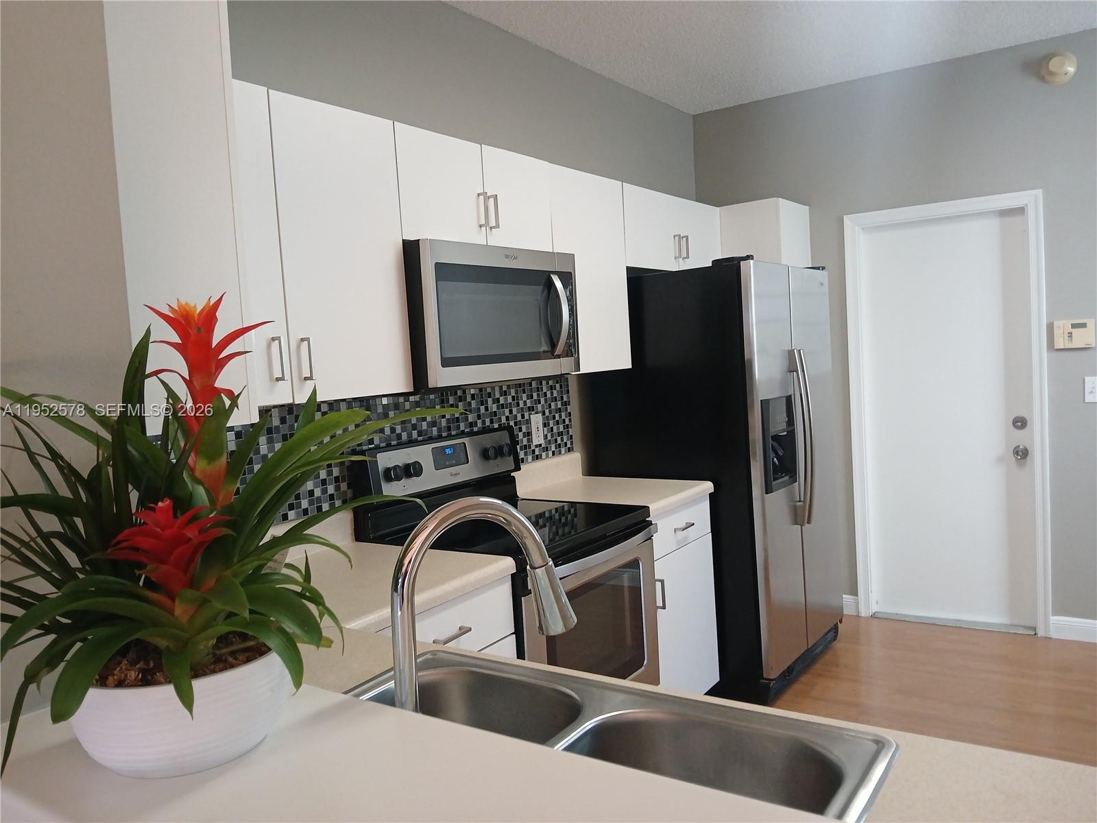 a kitchen with stainless steel appliances granite countertop a refrigerator and a sink