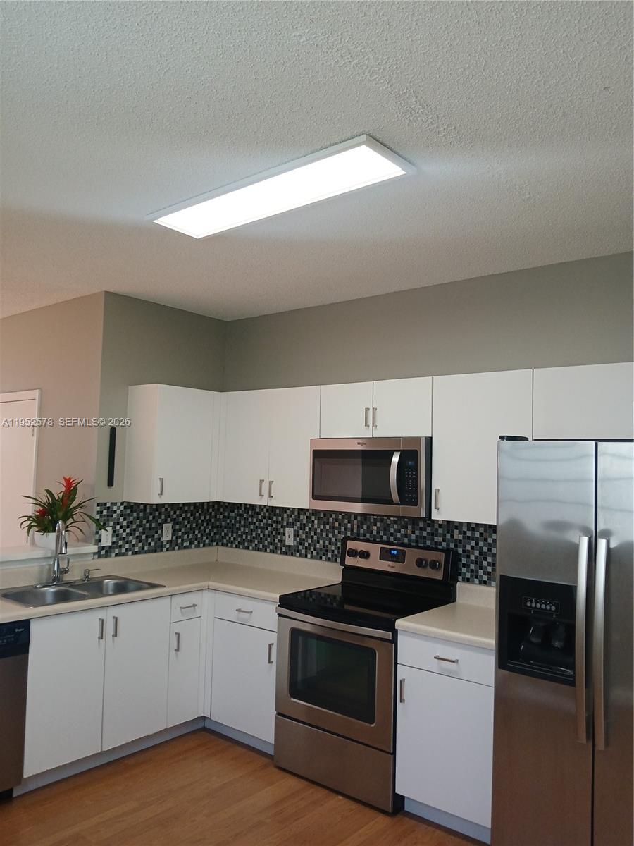 3618 San Simeon Circle, Unit 3618 Weston, FL 33331 - Photo 3 of 44 a kitchen with granite countertop a refrigerator stove and sink