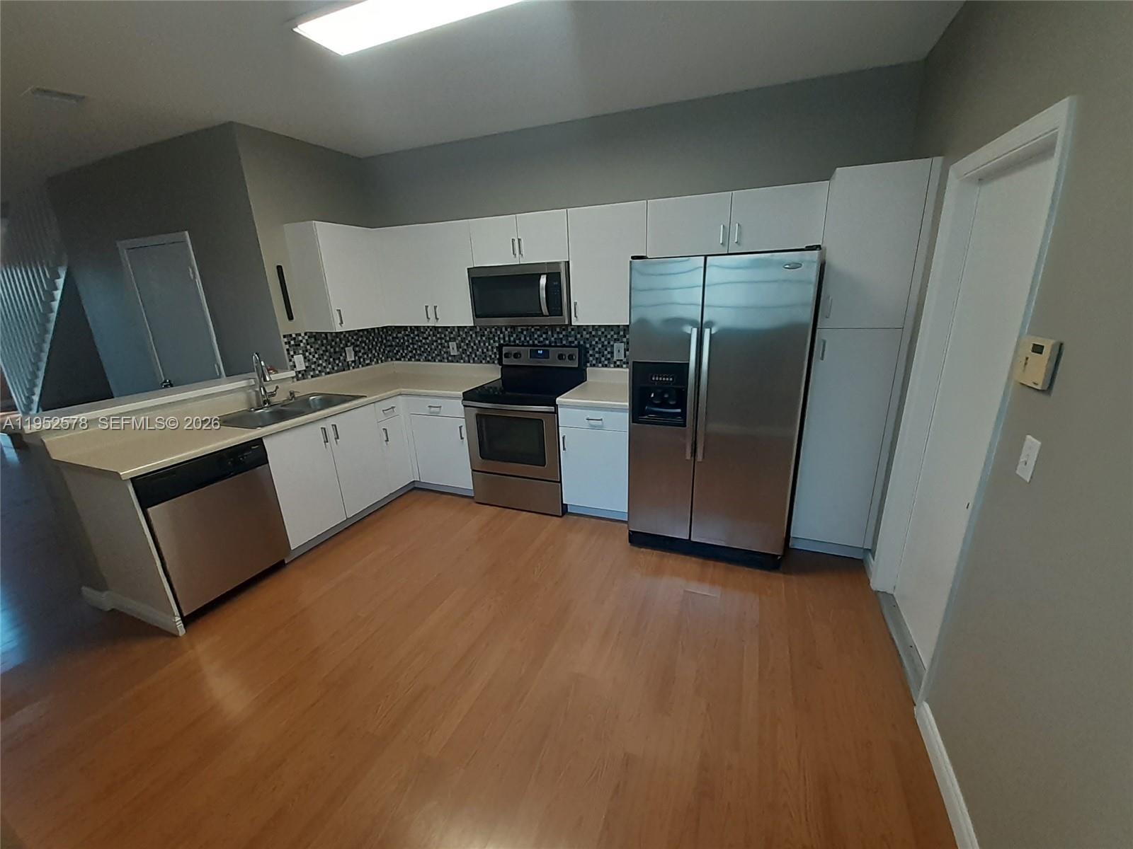 3618 San Simeon Circle, Unit 3618 Weston, FL 33331 - Photo 4 of 44 a kitchen with a refrigerator sink and microwave