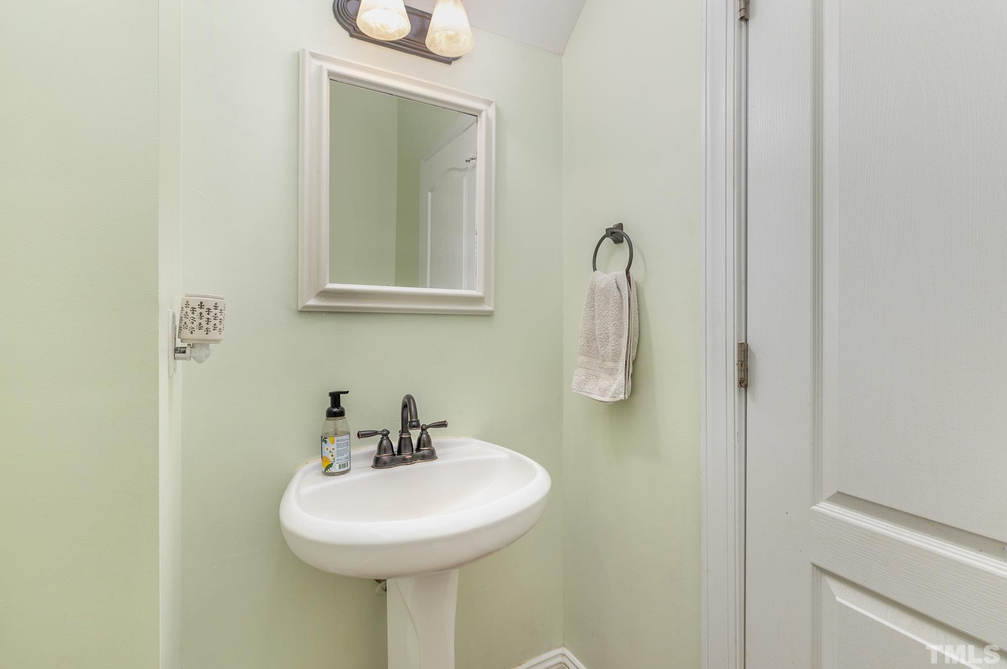 1308 Red Brick Road Garner, NC 27529 - Photo 31 of 31 a bathroom with a sink a mirror and shower
