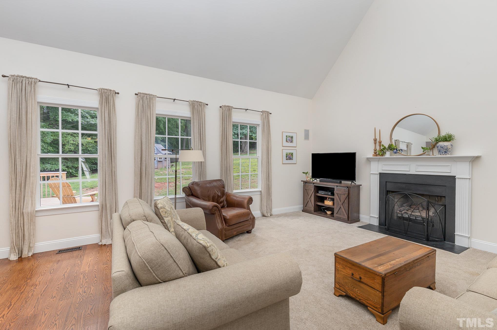 1308 Red Brick Road Garner, NC 27529 - Photo 4 of 31 a living room with furniture a flat screen tv and a fireplace