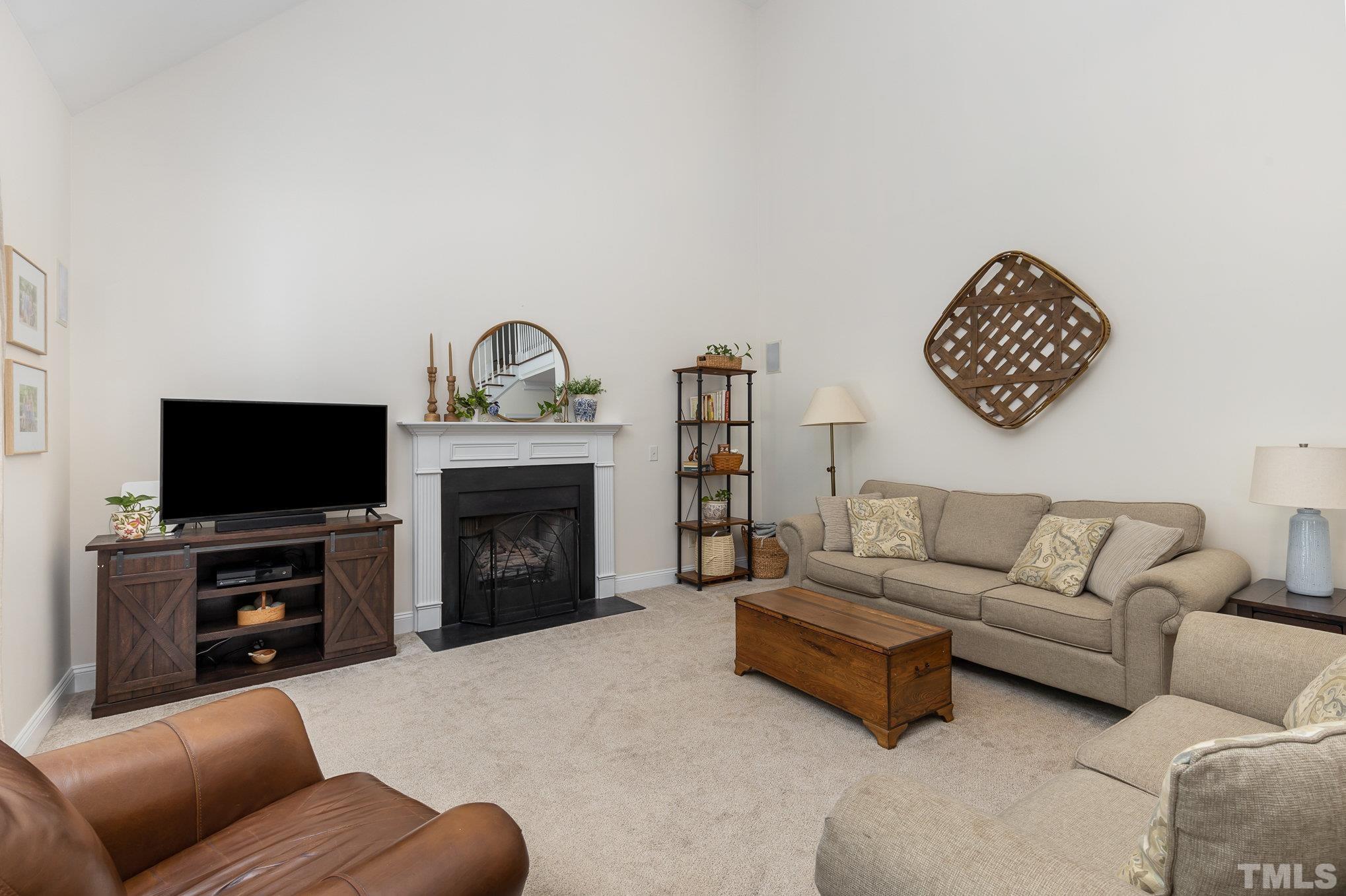 1308 Red Brick Road Garner, NC 27529 - Photo 5 of 31 a living room with furniture a fireplace and a flat screen tv
