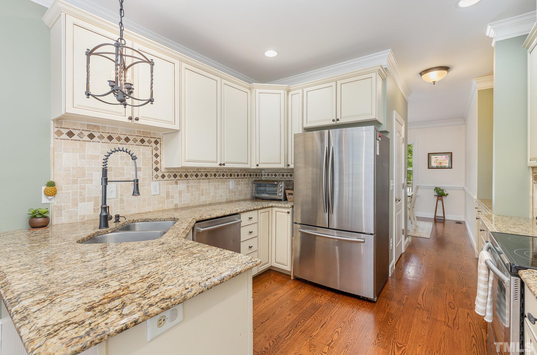 1308 Red Brick Road Garner, NC 27529 - Photo 9 of 31 a kitchen with stainless steel appliances granite countertop a refrigerator a stove and white cabinets with wooden floor