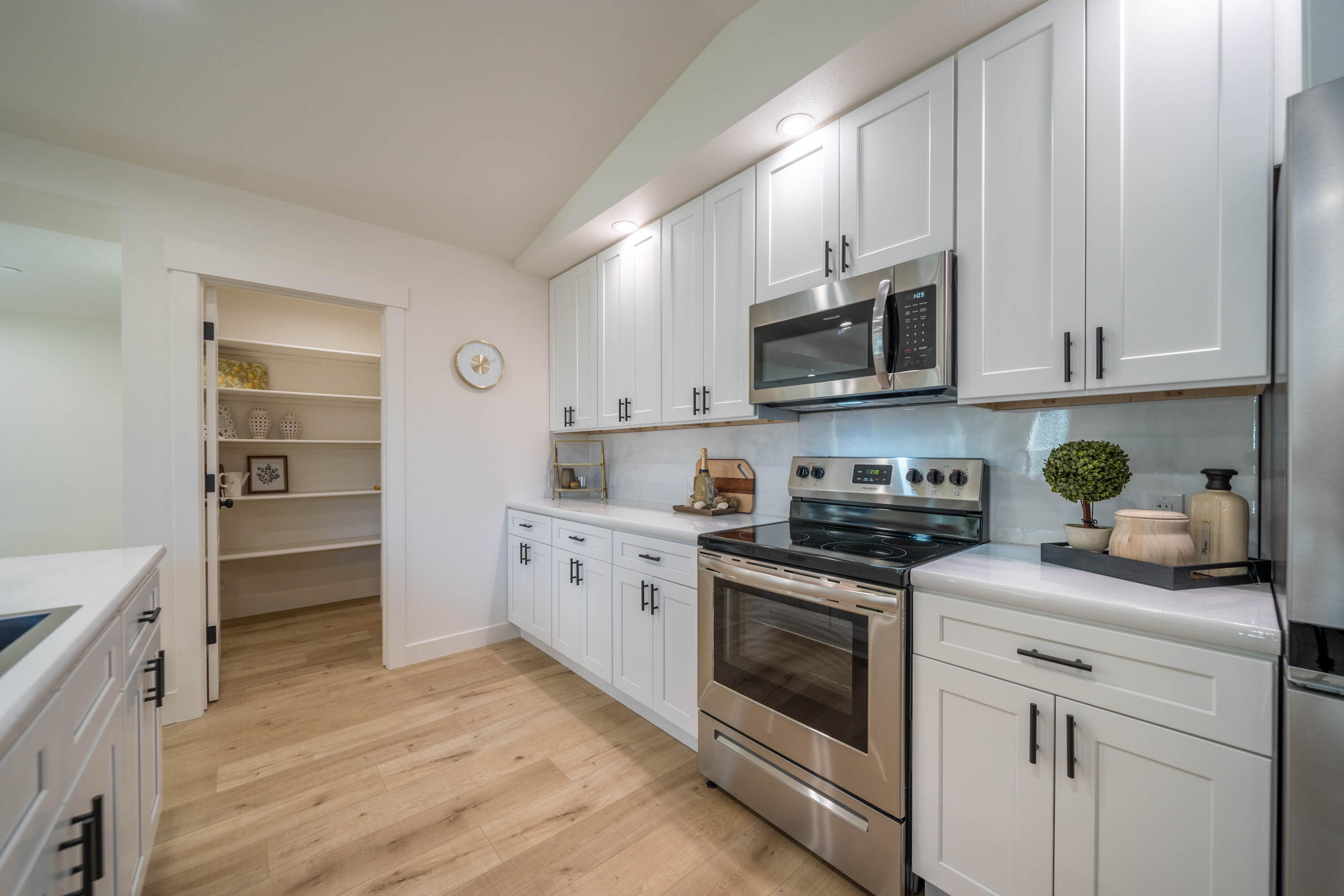 1387 Ridge Drive Redding, CA 96001 - Photo 9 of 44 a kitchen with granite countertop white cabinets and stainless steel appliances