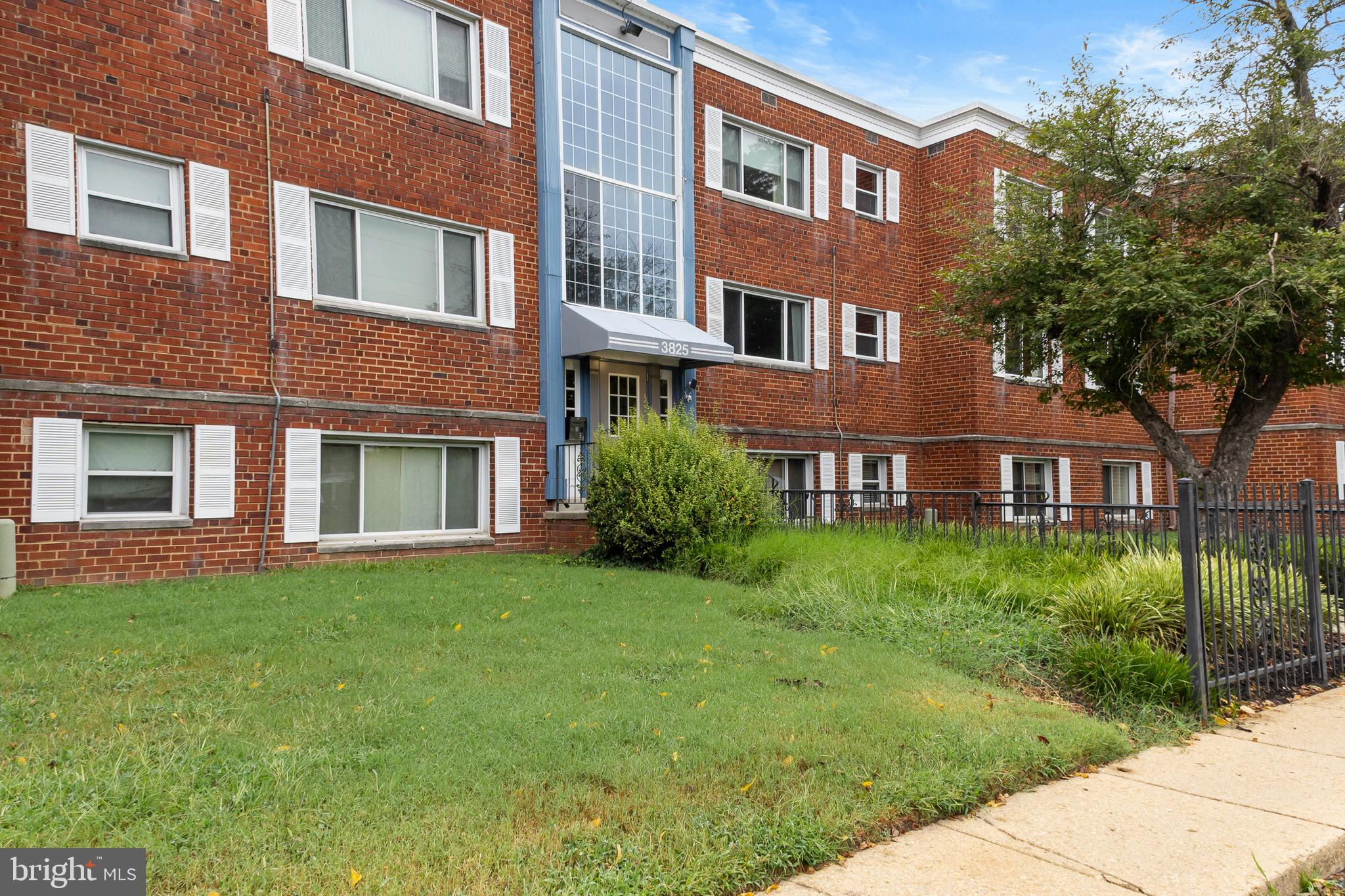 a view of a brick building next to a yard