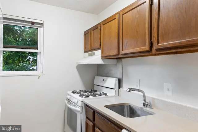a kitchen with a sink cabinets and a window