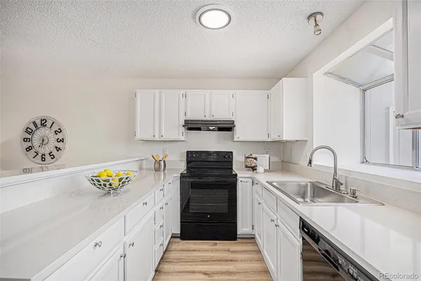 a kitchen with a sink stove and cabinets