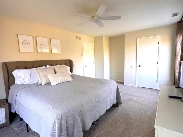 a bedroom with a bed and a large window