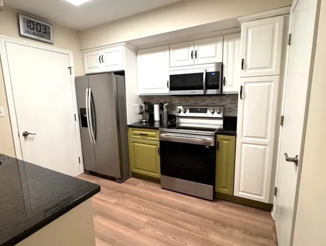 a kitchen with stainless steel appliances a refrigerator stove and microwave