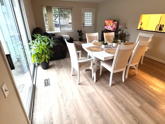 a dining room with furniture potted plants and wooden floor