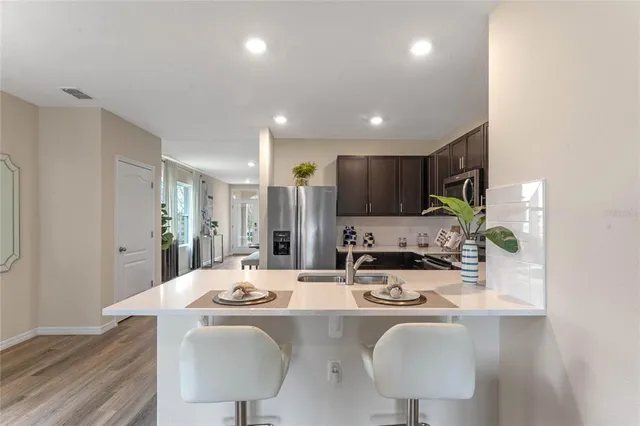 a dining room with kitchen island furniture a chandelier and kitchen view