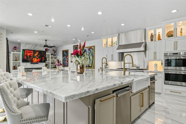 a kitchen with stainless steel appliances kitchen island granite countertop a table and chairs in it