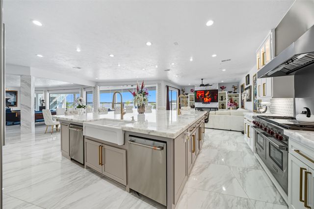 a kitchen with stainless steel appliances granite countertop a kitchen island a stove and a sink