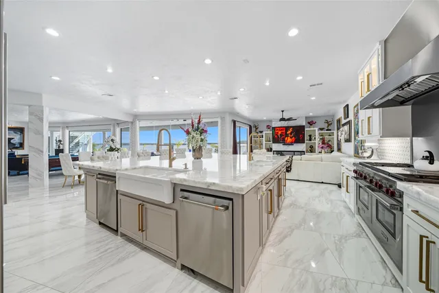 a kitchen with stainless steel appliances granite countertop a kitchen island a stove and a sink