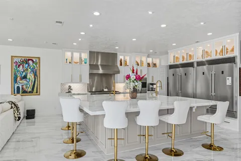 a kitchen with stainless steel appliances kitchen island granite countertop a table and chairs in it